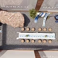 Maybach Display Area Featuring Blue White Striped Canopies Brick Walls Long Table And Stone Stools