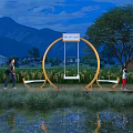 Garden Ornamental Circular Swing Installation with Natural Landscape Mountains Trees Pond and People Interacting