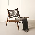 Lounge Chair Wooden Frame Woven Design With Gray Blanket Draped Over Minimalist White Wall