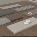 Various Rectangular Fabric Floor Cushions In Different Colors On Wooden Floor With Books