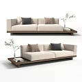 Cream Colored Two Seater Sofa With Wooden Base And Tray Holding Plant And Books