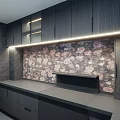Modern Black Kitchen Interior With Cabinet Lighting And Floral Backsplash
