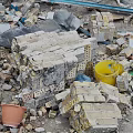 Pile of Construction Debris With Rubble Bricks Metal Sheets Yellow Blue Buckets And Dirt Path