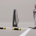 Man in Suit Standing Near Electric Vehicle Charging Station in Parking Area