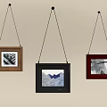 Three Framed Paintings Hanging On Light Colored Wall With Different Artworks