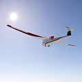 Red And White Glider Flying In Clear Blue Sky Under Bright Sun