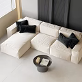 Modern Cream Colored Three Seater Sofa With Black Cushions And Round Coffee Table