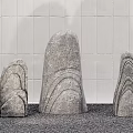 Natural Stone Sculptures With Wooden Accents Against White Tiled Wall And Gravel Ground
