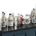 Assorted Beverage Bottles Including Tonic Water Juice And Soda On Black Countertop