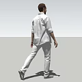 Man In Casual Gray Shirt And Pants Standing Against Simple Background