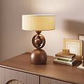 Modern Brown Table Lamp With Cream Pleated Lampshade And Double Sphere Base On Wooden Cabinet