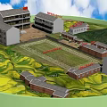 School Buildings Complex With Central Playground And Red Flag In Green Mountainous Fields