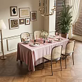 Elegant Dining Table Set With Pink Tablecloth Wicker Chairs Chandelier And Potted Plant