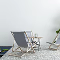 Small Outdoor Table With Gray Lounge Chairs Green Plants Pebble Floor And Water Pond