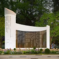 White Curved Building Facade with Inscriptions Surrounded by Green Trees Plants and Flower Beds