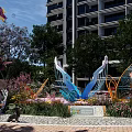 Urban Park Landscape With Butterfly Sculpture Girl Blowing Bubbles Flowers And Trees