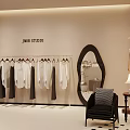 Modern Clothing Store Interior With Hanging White And Dark Clothes Oval Mirror And Black Chair