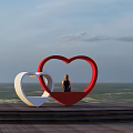 Seaside Ocean View With Red And White Heart Shaped Sculptures And Person Sitting