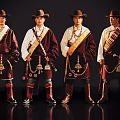 Group of Four Men in Traditional Ethnic Costumes With Hats Robes and Decorative Ornaments