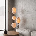 Abstract Floor Lamp With Three White Shades Black Metal Stand Gray Concrete Wall Mountain View