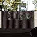 Modern Building Exterior Wall With Wooden Slat Gate Wall Lamps Surrounded By Trees