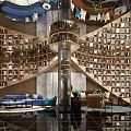 Modern Shop Front Desk Area With Wooden Reception Counter Bookshelves Sofa And Green Plants