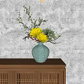 Green Ceramic Vase With Yellow Flowers And Green Branches On Wooden Cabinet Against Gray Wall