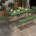 Commercial Outdoor Seating Space With Green Metal Table Chairs Bench And Plant Decorations