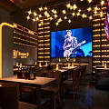 Bravo Bar Interior With Big Screen Live Music Tables Chairs And Wine Bottles