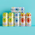 Colorful Canned Fruit Drinks With Various Flavors And Patterns On Light Blue Background