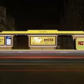 Illuminated Public Transport Bus Stop With Yellow Structure And Advertising Billboards At Night
