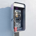 Public Phone Booth With Graffiti And Coca Cola Cup On Gray Wall
