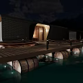 Row Of Lit Water Buildings At Night With Mountain Backdrop And Reflections