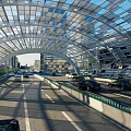 Modern Arch Shaped Road Infrastructure With Transparent Roof Metal Framework And Vehicles