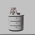Modern White Bedside Table With Three Drawers And Doll Mug On Top