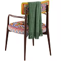 Vibrant Accent Chair With Colorful Patterned Seat Wooden Armrests And Green Throw Blanket