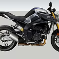 Black Sporty Motorcycle With Golden Accents Against Mountain Forest And Blue Sky