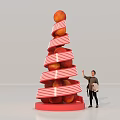 Person Standing Next To Decorative Peach Tower With Red And White Stripes Holding Shopping Bag
