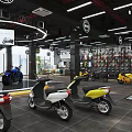 Modern Scooter Store Displaying Colorful Scooters Helmets And Large Screen Interior