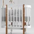 White Frame Baby Crib With Wooden Posts Gray Mattress And Hanging Mobile