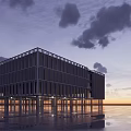 Modern Glass Building Exterior At Sunset With Cloudy Sky And Reflections