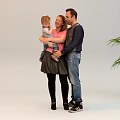 Group of People Interacting Indoors With Adults Dressing Children And Hugging