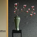 Green Vase With Pink Flowers On Black Table Against Textured Dark Wallpaper