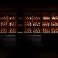 Illuminated Modern Wine Cabinet Lined With Various Wine Bottles In Dark Room