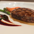 Grilled Steak Plated with Green Vegetables Carrots and Red Sauce on White Square Plate
