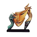 Abstract Sculpture With Orange Mask Face Green Hands And Black Base