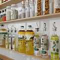 Neatly Arranged Various Spice Bottles On Kitchen Shelves With Stove And Pans