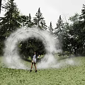 Photo Check-in Spot With Foggy Ring On Grassland Surrounded by Trees And Standing Person