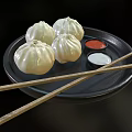 Delicious Steamed Buns on Black Plate with Red and White Sauces and Chopsticks