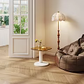 Modern Round Top Side Table With White Base Near Bean Bag Chair And Floor Lamp